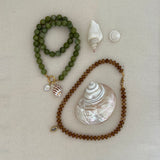 green jade and caramel jade beaded base necklaces with gold clasps, styled with pearl and gold charms