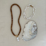caramel jade beaded necklace and pearl necklace with gold clasps, styled with pearl and gold charms