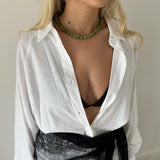 Green jade beaded choker necklace with gold clasp worn for layering
